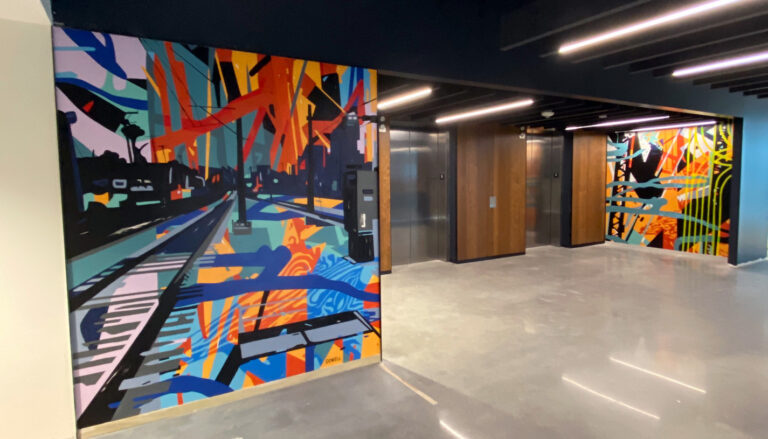 These two lobby murals for EY’s Rail Trail South End location incorporate themes of innovation, connection, the coexistence of man and nature and growth through nods to train tracks, abstracted tree bark, trusses and vibrant color.