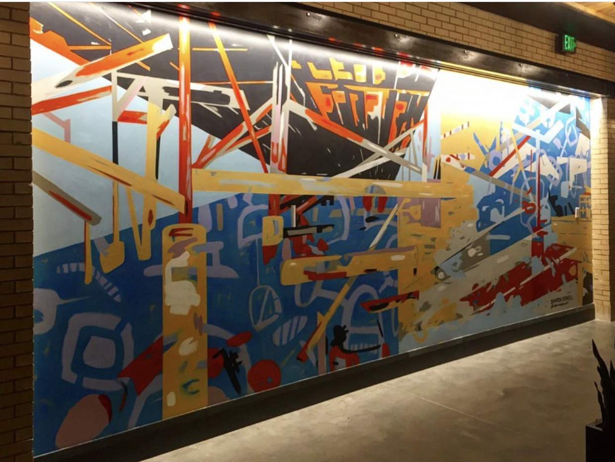 9' x 22' abstract, asymmetrical mural in 3 quadrants with linear design resembling deconstructed bridge trellis in upper left quadrant. Bold fire colors, cool blues, grays and black. In the elevator lobby of The Refinery, a luxury office building in Charlotte.
